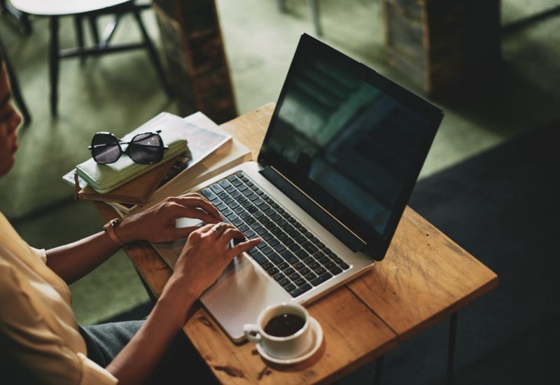 unrecognizable-asian-woman-sitting-cafe-working-laptop